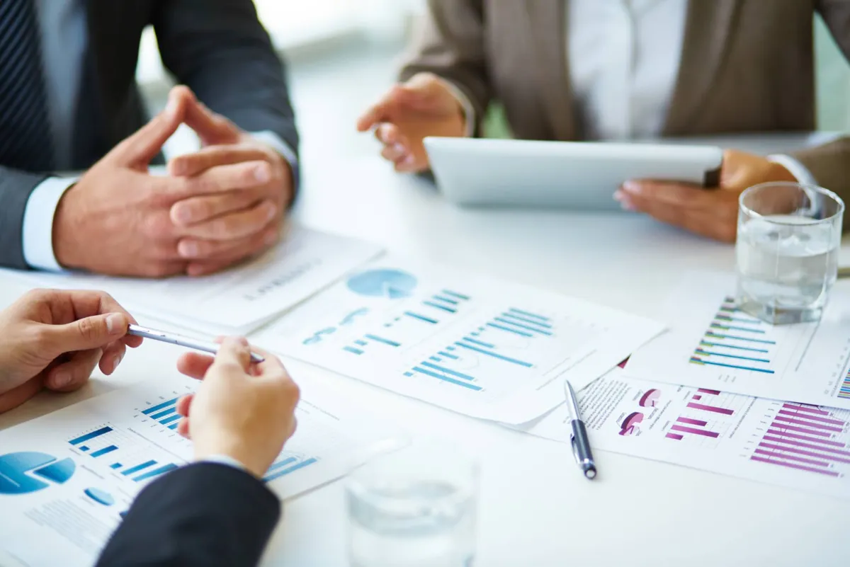 Team reviewing printed charts and reports at a meeting table